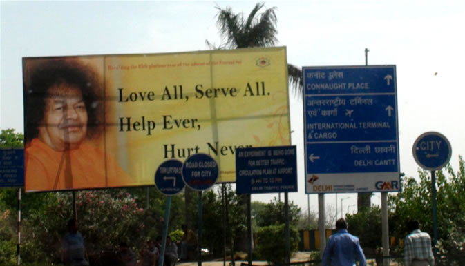 AD ON THE ROAD SIDE IN DELHI LOVE ALL SERVE ALL SWAMI ARRIVES IN DELHI TODAY 9TH APRIL 2010 - WELCOME
